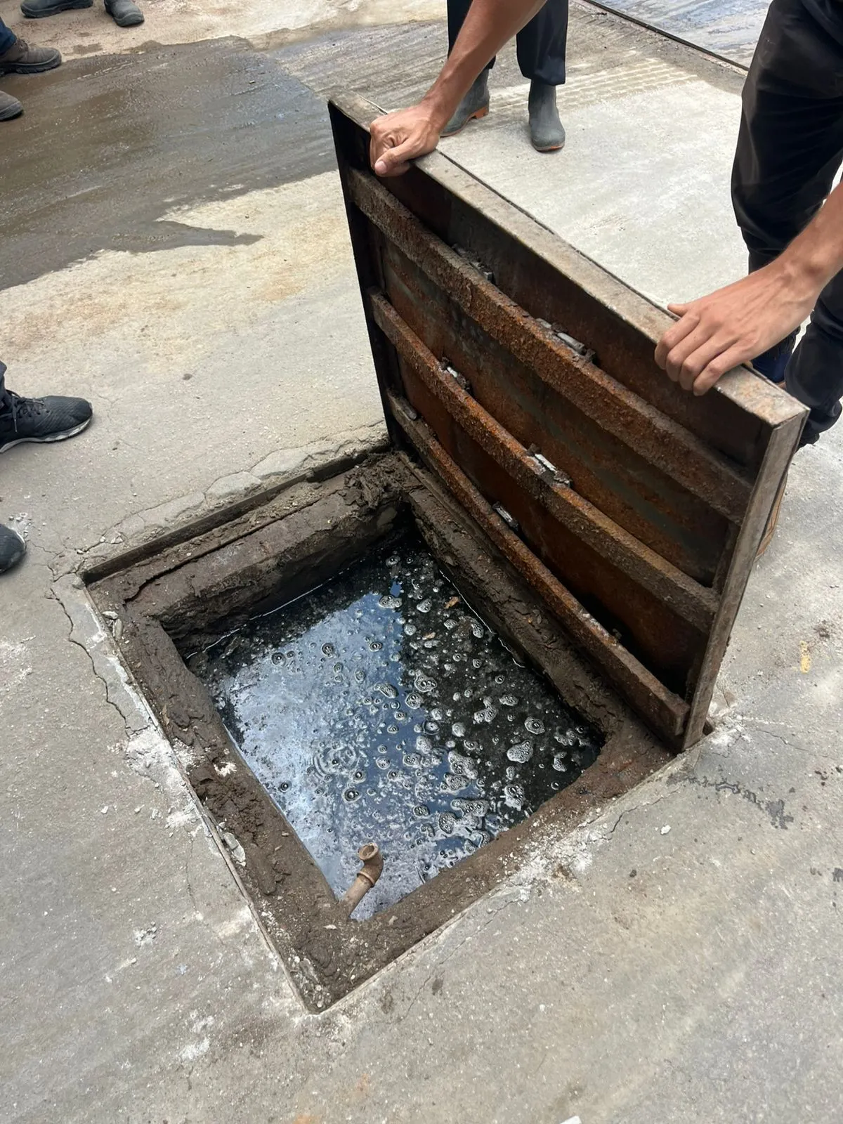 Caixa de gordura aberta para limpeza, com camada de gordura na superficie, em Curitiba em atendimento de desentupimento em cafeteria