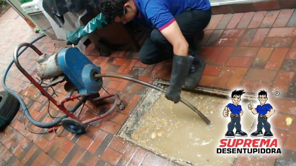 Técnico da Suprema desentupindo vaso sanitário em atendimento residencial em Curitiba em atendimento de desentupimento em auditório